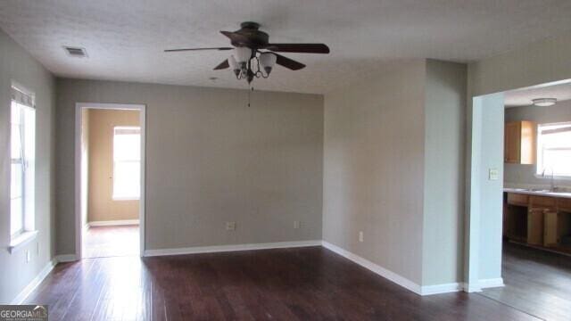 empty room featuring ceiling fan, dark hardwood / wood-style flooring, and sink