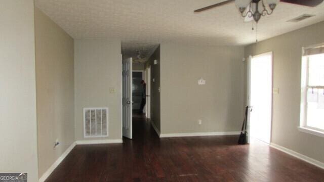 spare room featuring ceiling fan and dark wood-type flooring