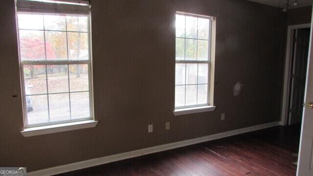 empty room with dark hardwood / wood-style flooring