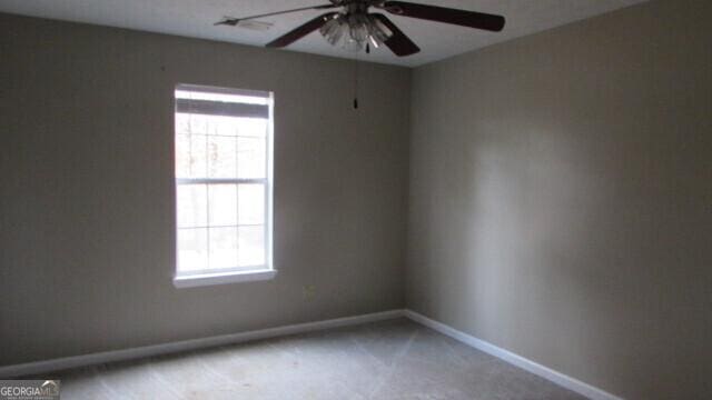 carpeted empty room featuring ceiling fan