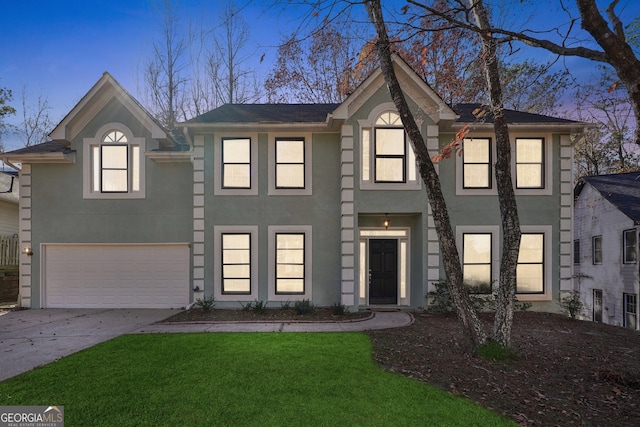 view of front facade with a garage and a yard