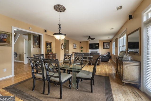 dining space with ceiling fan and wood-type flooring