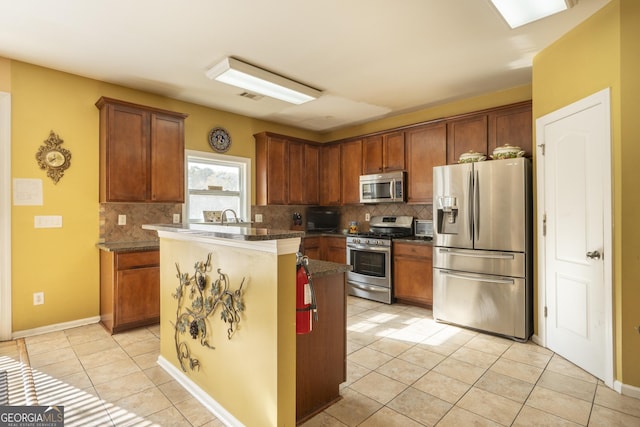 kitchen with backsplash, stainless steel appliances, a kitchen island, and sink