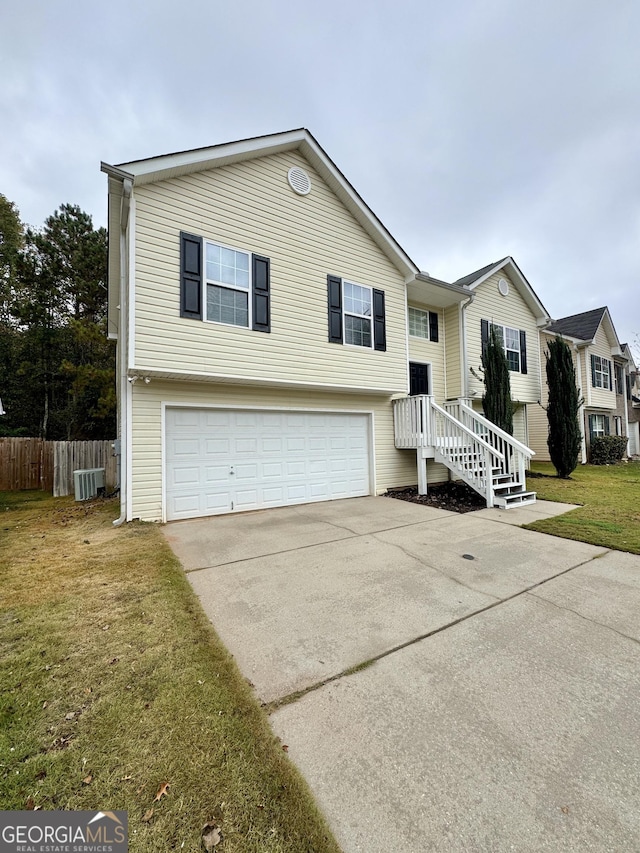 view of front of home with central AC, a front yard, and a garage