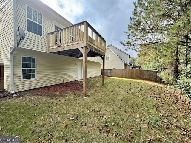 back of property featuring a yard and a wooden deck