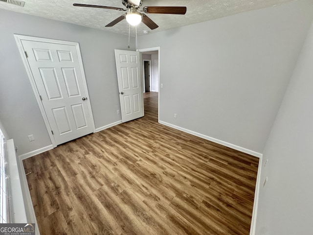 unfurnished bedroom with ceiling fan, hardwood / wood-style floors, and a textured ceiling