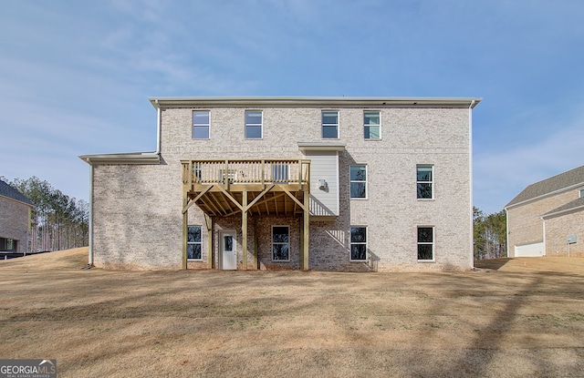 back of house with a deck and a yard