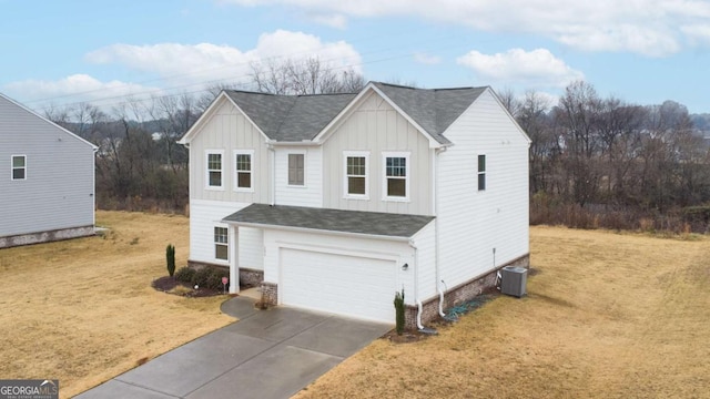 view of front of property featuring central air condition unit, a front yard, and a garage