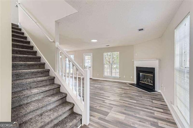 stairway featuring wood-type flooring and a textured ceiling