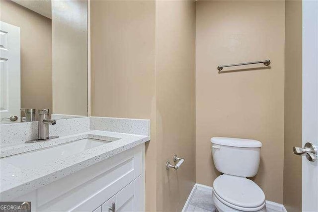 bathroom featuring tile patterned flooring, vanity, and toilet