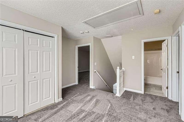 unfurnished bedroom featuring carpet flooring, a closet, and a textured ceiling