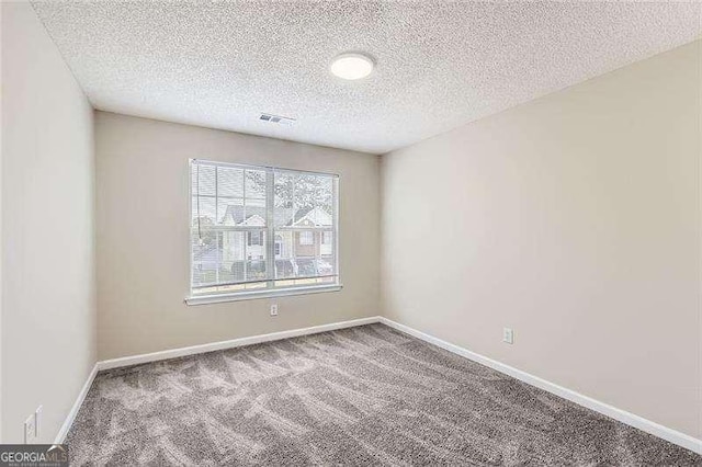 carpeted spare room featuring a textured ceiling