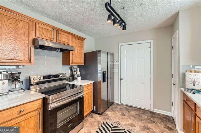 kitchen featuring appliances with stainless steel finishes, a textured ceiling, and tasteful backsplash