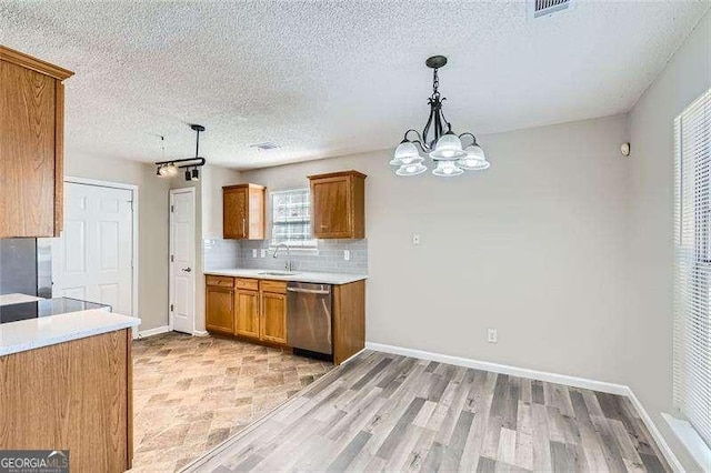 kitchen featuring dishwasher, sink, hanging light fixtures, light hardwood / wood-style floors, and a chandelier