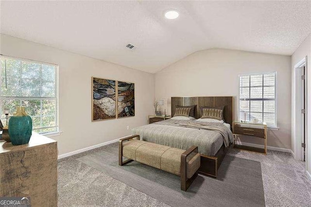 bedroom with a textured ceiling, light carpet, and vaulted ceiling