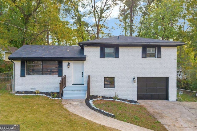 tri-level home featuring a garage and a front lawn