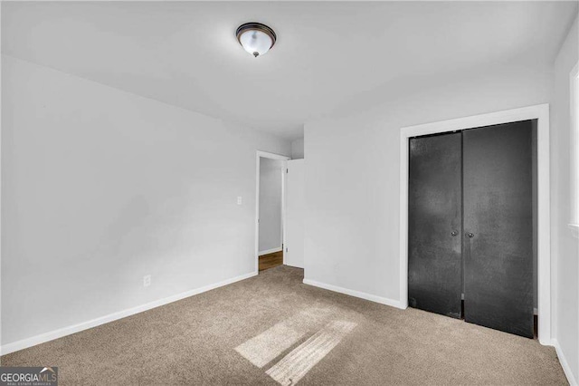 unfurnished bedroom with carpet flooring and a closet