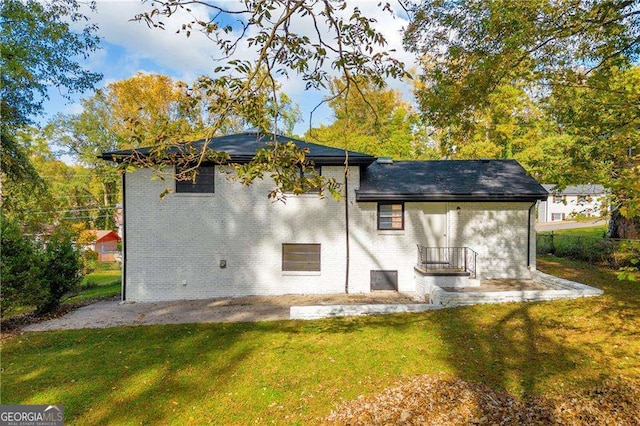 rear view of property featuring a patio area and a yard