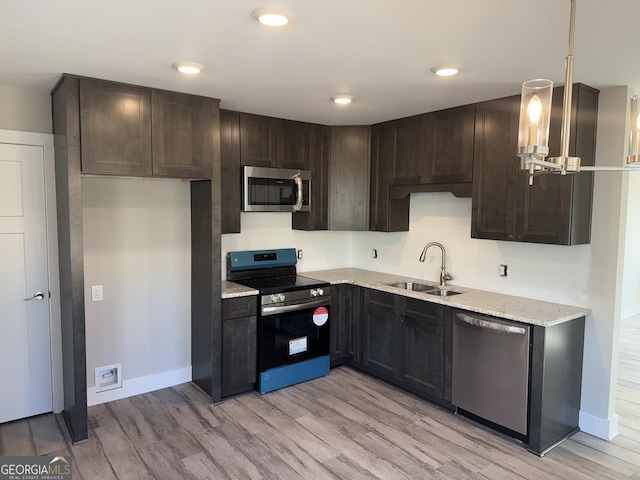 kitchen with light wood-type flooring, a sink, stainless steel appliances, dark brown cabinetry, and baseboards