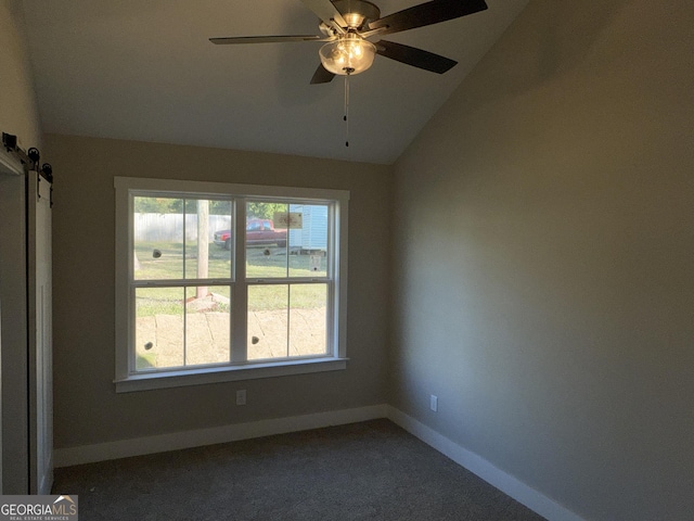 unfurnished room featuring a barn door, baseboards, carpet flooring, lofted ceiling, and ceiling fan