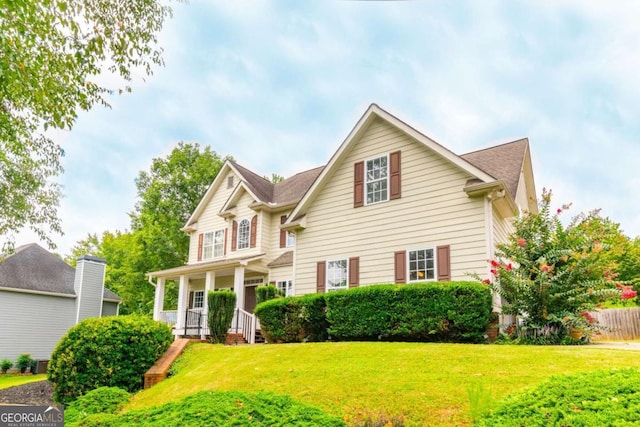 view of front of house with covered porch and a front yard