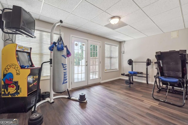 exercise room with wood-type flooring and a drop ceiling