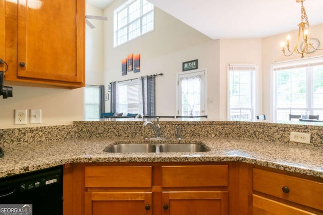 kitchen with light stone countertops, black dishwasher, a notable chandelier, and sink