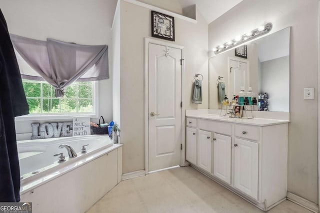 bathroom with a tub to relax in, vanity, and vaulted ceiling