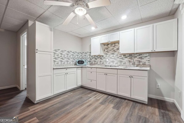 kitchen with dark hardwood / wood-style flooring, ceiling fan, sink, and white cabinets