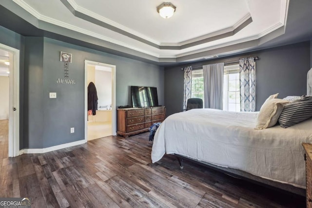 bedroom featuring ensuite bath, ornamental molding, dark wood-type flooring, and a tray ceiling