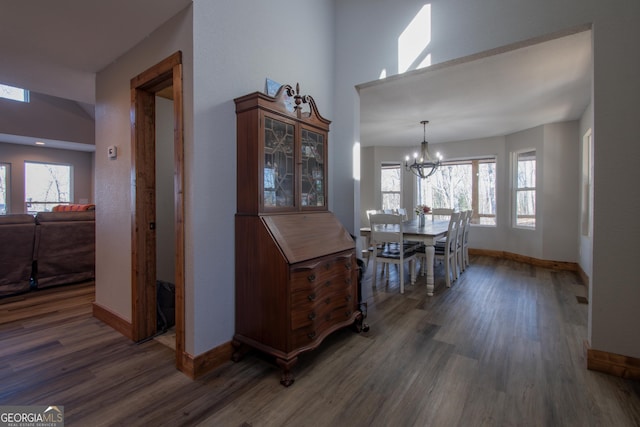 dining area with dark hardwood / wood-style flooring and a chandelier