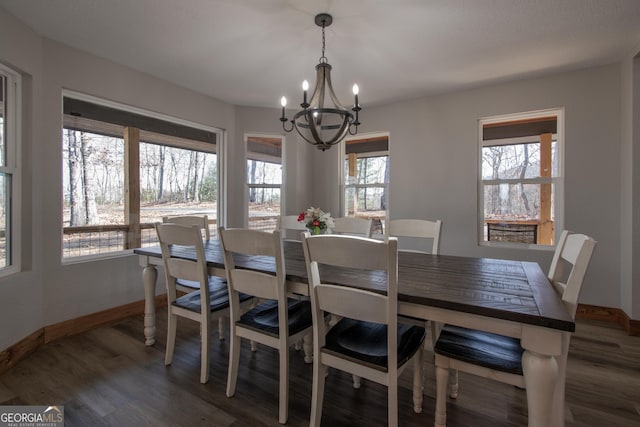 dining room with dark wood-type flooring and a notable chandelier