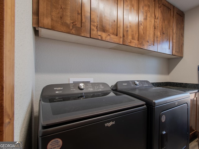 washroom featuring cabinets and washing machine and clothes dryer