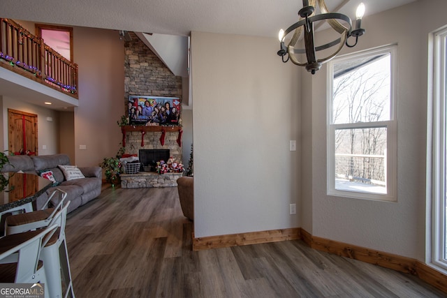 interior space featuring a fireplace, dark wood-type flooring, and an inviting chandelier