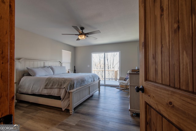 bedroom featuring access to outside, ceiling fan, and dark wood-type flooring