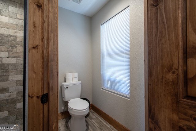 bathroom featuring wood-type flooring and toilet