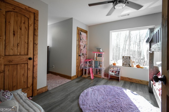 recreation room with ceiling fan and dark wood-type flooring