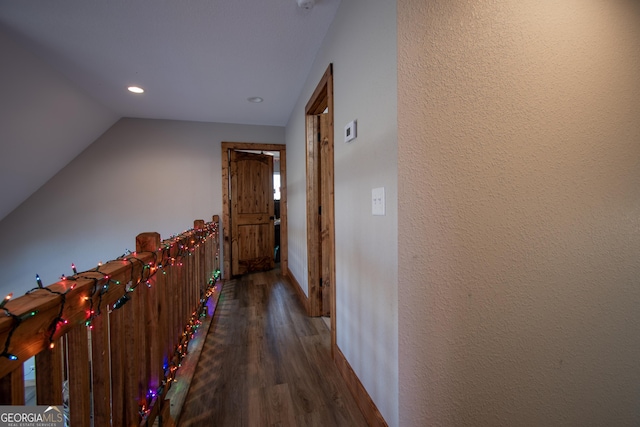 hallway featuring vaulted ceiling and dark wood-type flooring