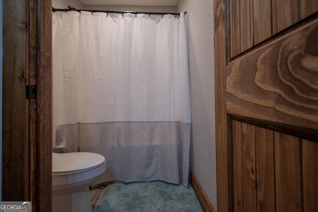 bathroom with curtained shower and toilet