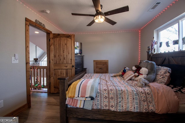 bedroom featuring a textured ceiling, dark hardwood / wood-style flooring, and ceiling fan