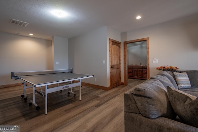 game room with wood-type flooring and a textured ceiling