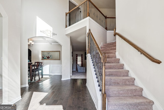 interior space featuring hardwood / wood-style floors, a towering ceiling, and an inviting chandelier