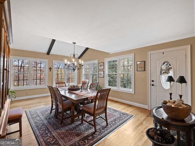 dining space with a chandelier, lofted ceiling with beams, light hardwood / wood-style flooring, and plenty of natural light