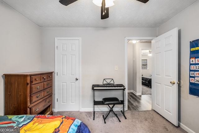 bedroom with carpet, a textured ceiling, and ceiling fan