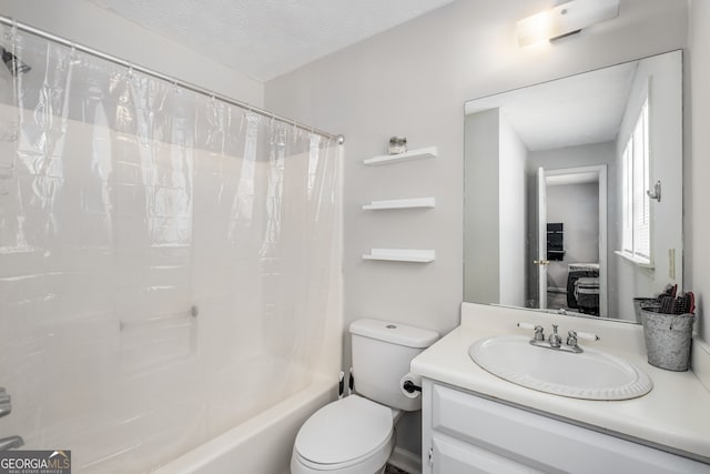 full bathroom with vanity, toilet, shower / bath combo with shower curtain, and a textured ceiling