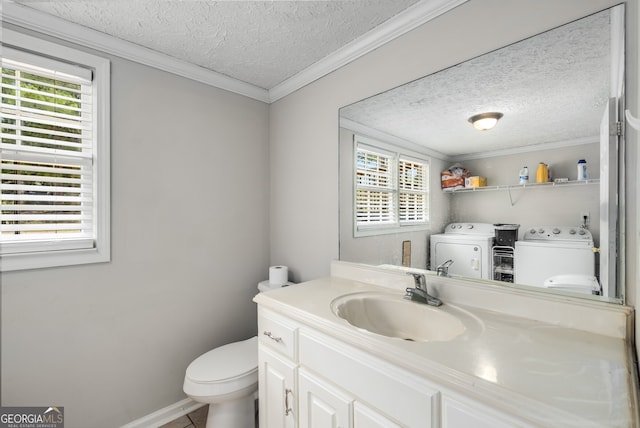 bathroom featuring washer and clothes dryer, vanity, toilet, ornamental molding, and a textured ceiling