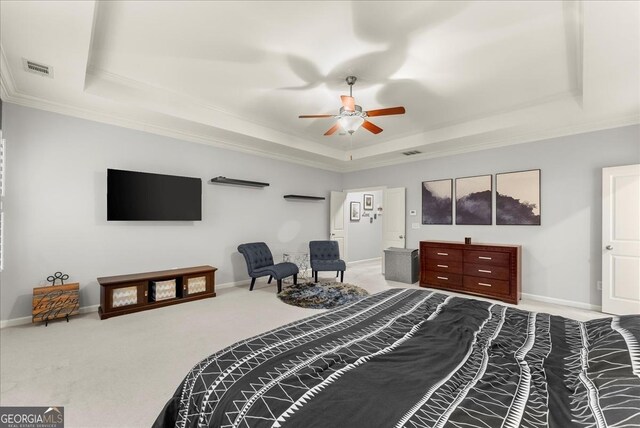 bedroom with a raised ceiling, ceiling fan, crown molding, and carpet flooring