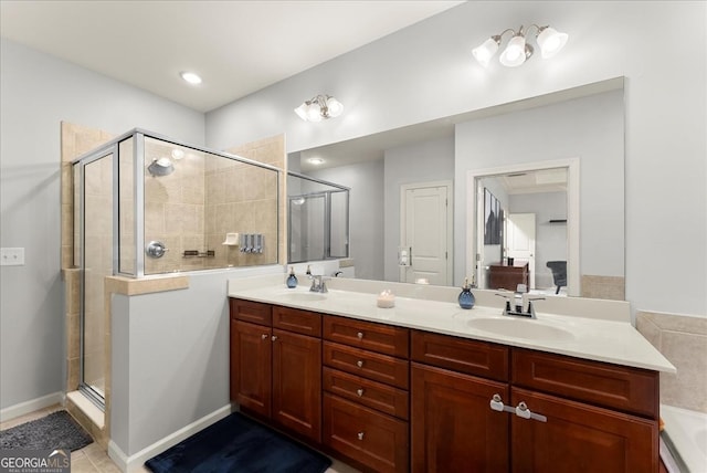 bathroom featuring tile patterned flooring, vanity, and tiled bath