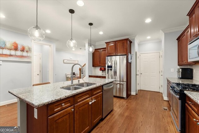 kitchen featuring ceiling fan with notable chandelier, sink, dishwasher, light hardwood / wood-style floors, and an island with sink