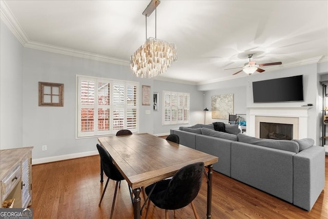 dining area featuring dark hardwood / wood-style flooring, an inviting chandelier, and ornamental molding